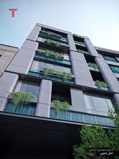 a tall building with lots of windows and plants on the balconies