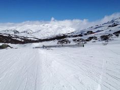 a person riding skis down a snow covered slope in front of a mountain range