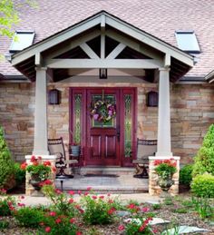 the front entrance to a home with flowers and shrubs