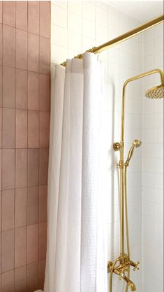 a bathroom with a shower, toilet and pink tiled walls in it's corner