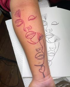 a person with a tattoo on their arm that has flowers and faces drawn on it