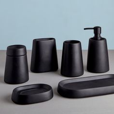 black bathroom accessories sitting on top of a counter