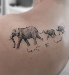 an elephant tattoo on the back of a woman's shoulder with words written across it