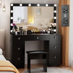 there is a vanity with lights on it and a stool in front of the mirror