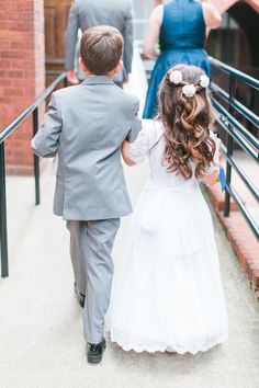 a young boy and girl are walking down the stairs