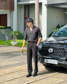 a man standing next to a black suv