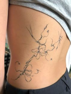 a woman's stomach with flowers and leaves drawn on the side by tattoo artist