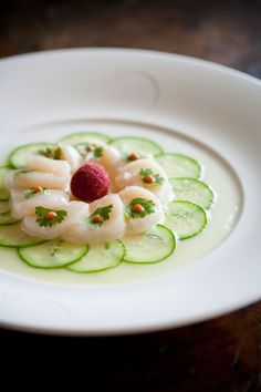 a white plate topped with cucumber and shrimp