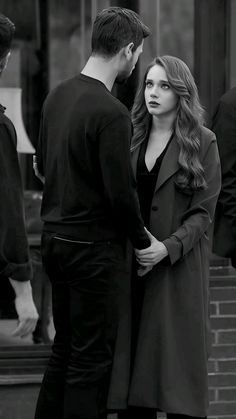 a man and woman standing next to each other in front of a building with stairs