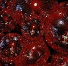 many shiny red disco balls are stacked together