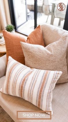 some pillows are sitting on a couch in front of a sliding glass door