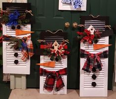 two snowmen made out of shutters decorated with plaid bows and pineconis