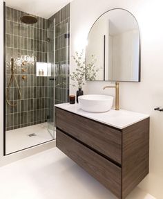 a bathroom with a sink, mirror and shower stall in it's own area