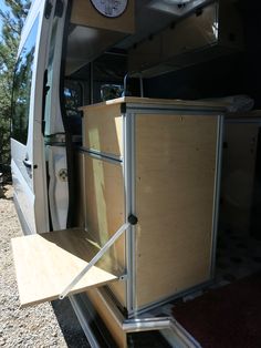 the back end of a van with its door open and shelves in place for storage