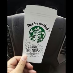 someone holding up a starbucks cup in their car