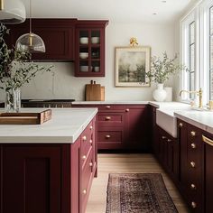 a kitchen with red cabinets and white counter tops