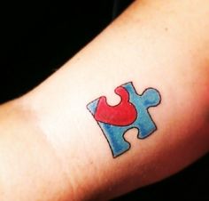 a person with a tattoo on their arm has a puzzle piece in the shape of a heart