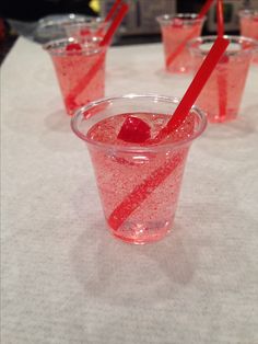 four glasses filled with red liquid on top of a white table cloth covered tablecloth