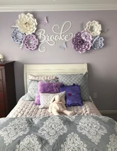 a bed with purple and white flowers on the wall