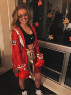 a woman wearing red boxing gloves standing in front of a window with stars on it