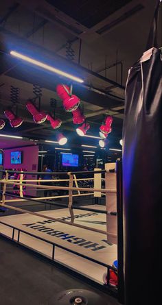 a boxing ring with red gloves hanging from the ceiling