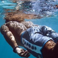 a man is swimming in the water with his head under the water's surface