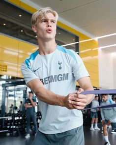 a young man holding a tennis racquet in a gym