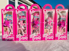 three barbie dolls in pink boxes on the snow