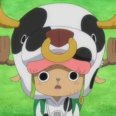 an anime character is holding on to a cow's head in front of green grass