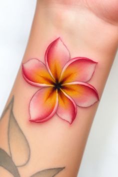 a pink and yellow flower on the wrist