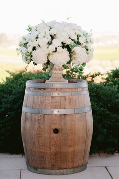 a wooden barrel with white flowers in it