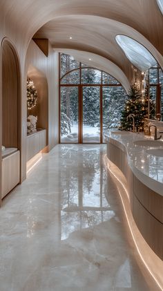 a large bathroom with white marble flooring and arched windows overlooking the snow covered trees