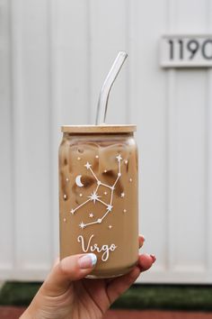 a person holding up a mason jar with a straw in it that says virgo