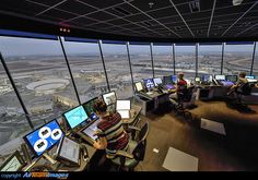 people sitting at desks in front of large windows looking out on the city below