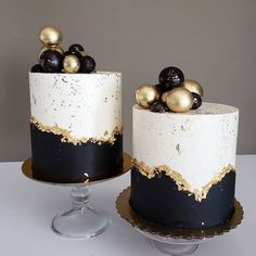 two black and white cakes with gold decorations on each cake stand, one is decorated with frosting