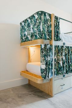 a bunk bed with green and white curtains