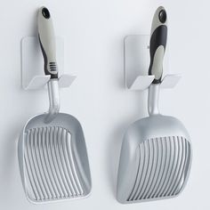 two spatulas hang on the wall next to each other