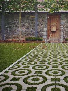 a stone building with a wooden door in the center and grass growing on the ground