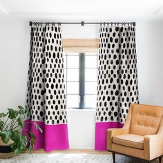 a chair sitting in front of a window next to a potted plant