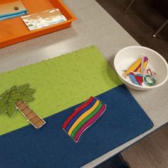 a table with a bowl, plate and paper cutouts sitting on top of it