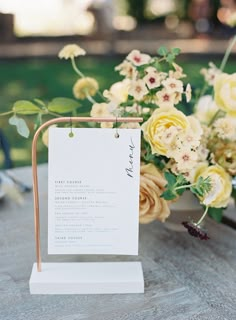 a table with flowers and a sign on it that says, wedding menu written in english