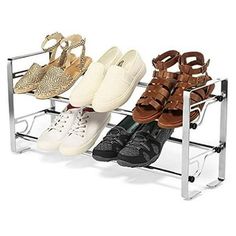 four pairs of shoes are sitting on a metal rack in front of a white background