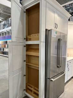 an open refrigerator in a store with shelves on both sides and drawers on the other side