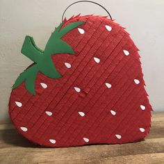 a strawberry shaped pillow sitting on top of a wooden table