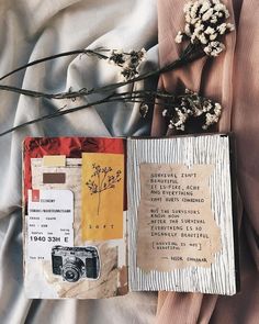 an open book sitting on top of a bed next to flowers