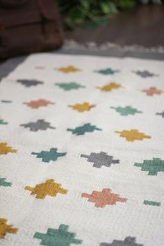 a white blanket with multicolored crosses on it