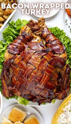 bacon wrapped turkey on a platter surrounded by other dishes and garnishes