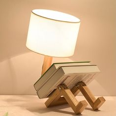 a lamp that is sitting on top of a wooden stand with a book in it