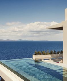 an outdoor swimming pool with the ocean in the background