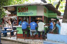 several people are sitting at a small food stand